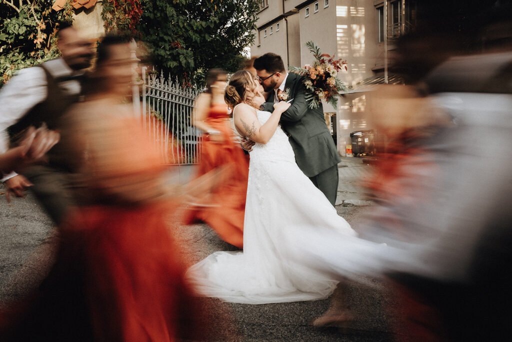 a man and woman kissing in front of a building